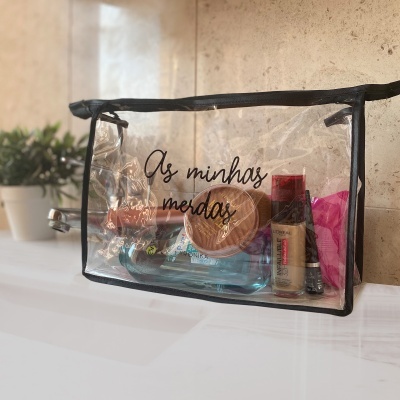 Necessaire transparente com texto, contendo produtos de maquilhagem