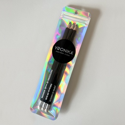 Pacote prateado holográfico com três lápis de cor pretos e rótulo Yronika