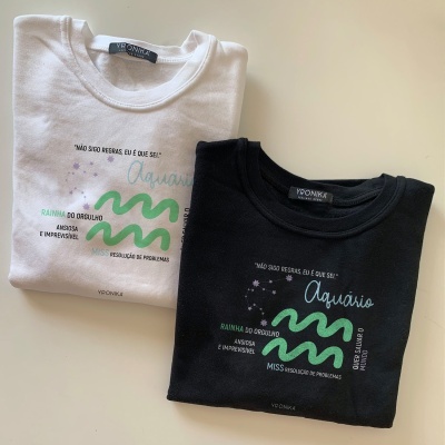 Dois sweatshirts, branco e preto, com estampado verde e texto alusivo ao signo Aquário