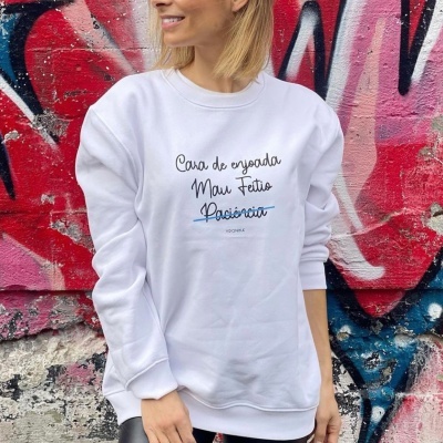 Sweatshirt branca com texto em várias fontes sobre fundo de grafite colorido