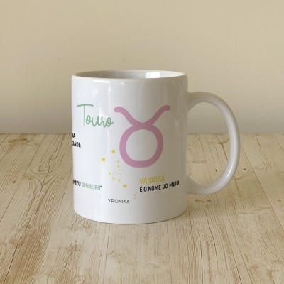 Caneca branca com símbolo e texto relacionado ao signo de Touro