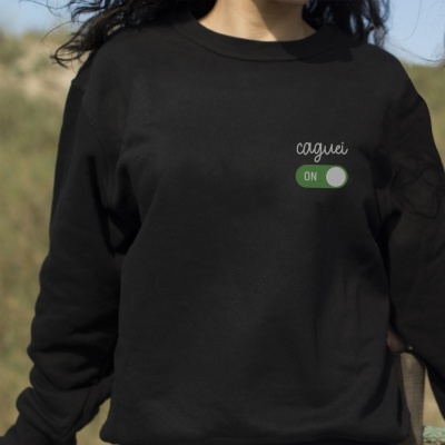 Sweatshirt preta com texto 'caguei' e botão ON verde no peito