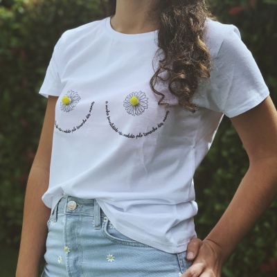 T-shirt branca com estampado de margaridas e calças de ganga claras com detalhes bordados