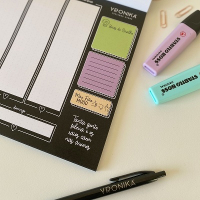 Bloco de notas adesivas coloridas, marcadores Stabilo Boss e caneta YRONIKA sobre mesa branca