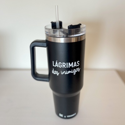 Caneca térmica preta com texto branco LÁGRIMAS das inimigas e tampa transparente com palhinha.