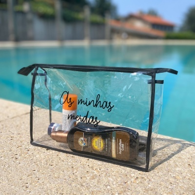 Saco de plástico transparente com bordas e fecho pretos, com texto em português, junto a uma piscina