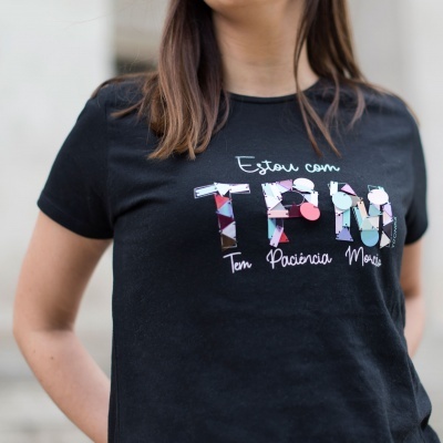 T-shirt preta com texto colorido 'Estou com TPM Tem Paciência Moço'