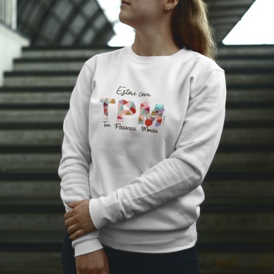 Suéter branco com estampa colorida e texto em português numa pessoa