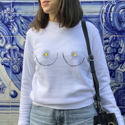 Camisola branca com estampa de margaridas e texto em português