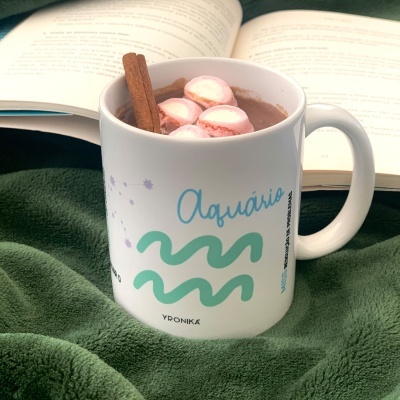 Caneca branca com design do signo Aquário com chocolate quente e marshmallows