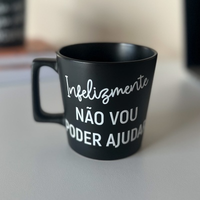 Caneca preta com texto branco Infelizmente NÃO VOU PODER AJUDAR sobre superfície clara