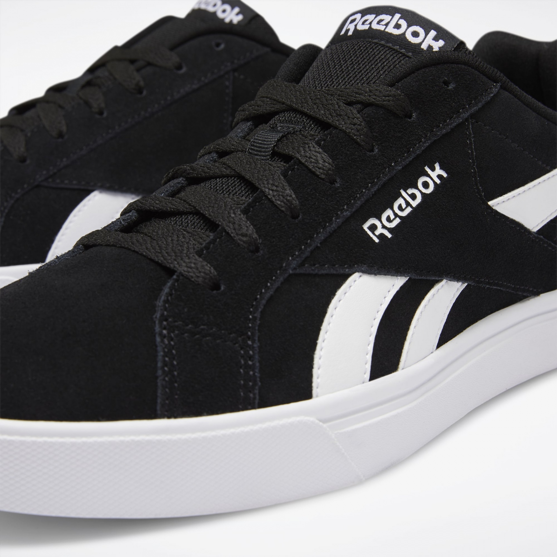 Ténis Reebok preto com detalhes brancos e sola branca em fundo claro