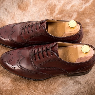 Par de sapatos sociais castanhos em pele sobre pele de animal