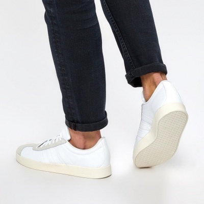 Ténis de couro branco com sola cremosa e calças pretas