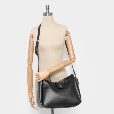 Bolsa preta DKNY com alça longa em manequim