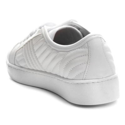 Ténis branco com padrão matelassê e sola espessa em fundo branco