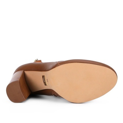 Sapato de salto castanho visto pela sola sobre fundo branco