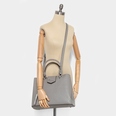 Mala cinzenta com alças duplas e longa em manequim com braços em madeira