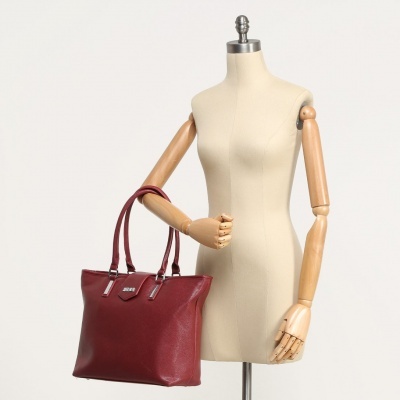 Mala de senhora em couro vermelho com pegas duplas exibida em manequim bege com braços de madeira