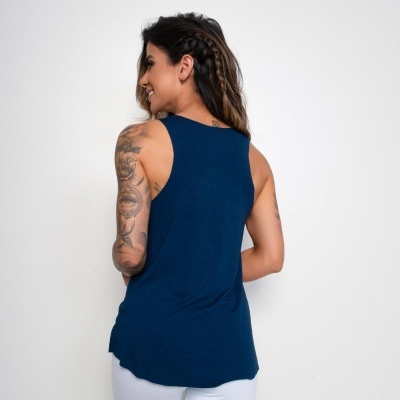Mulher de costas com camisola azul de alças largas sobre fundo branco