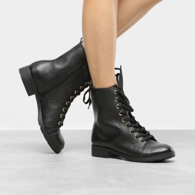 Botas pretas em pele texturada, com atacadores e ilhós dourados