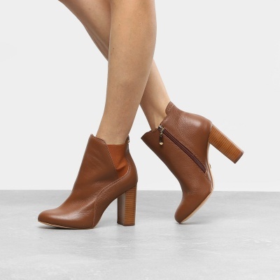 Botins de salto alto castanhos em pele com fecho lateral e salto largo de madeira.