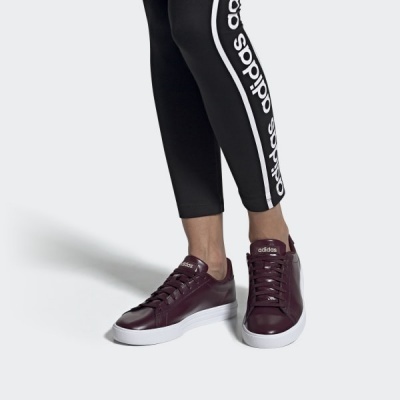 Sapatilhas Adidas bordeaux com sola branca usadas com calças pretas com logotipo Adidas