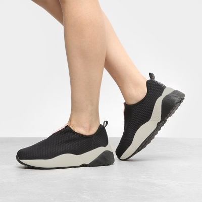 Ténis desportivos pretos e brancos em fundo neutro