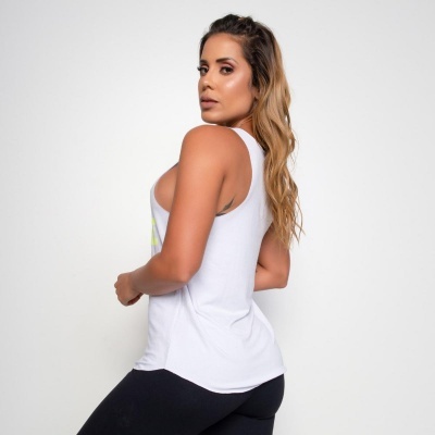 Mulher de costas com regata branca e calças pretas de tecido liso