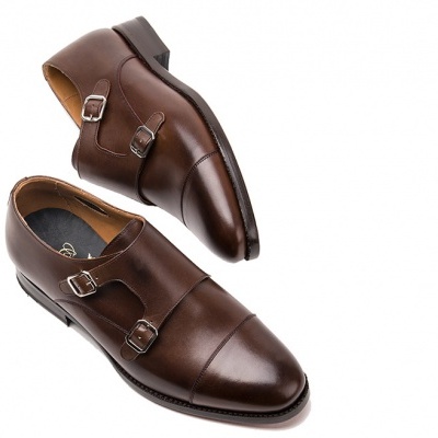 Sapatos masculinos castanhos de couro com fivelas e sola preta, fundo branco