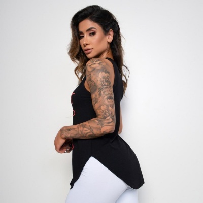 Mulher veste camiseta preta sem mangas e calças brancas