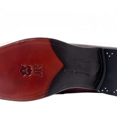 Sola de sapato de couro castanho e preto com detalhes dourados