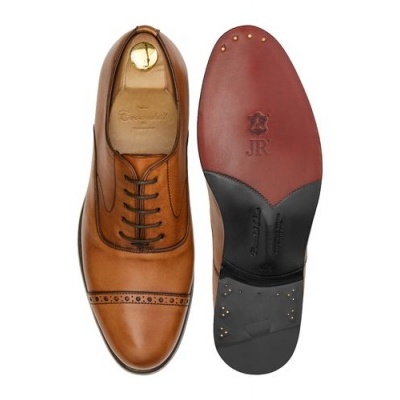 Sapatos formais de couro castanho com sola vermelha e preta