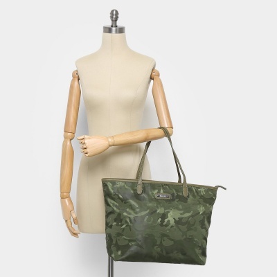 Mala tote camuflada verde com alças de pele exibida num manequim