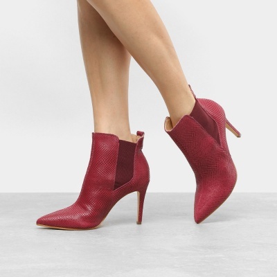 Botins vermelhos com salto alto fino e textura de pele de cobra
