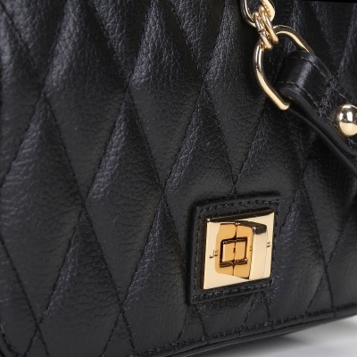 Mala preta de couro matelassé com fecho dourado quadrado e alça com detalhes dourados.