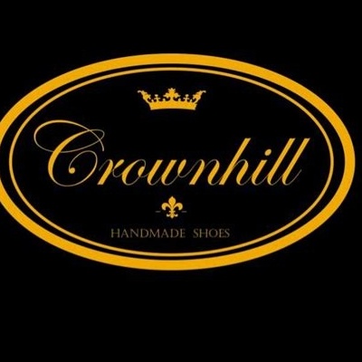 Logótipo Crownhill com coroa e texto Handmade Shoes em oval preto com borda alaranjada