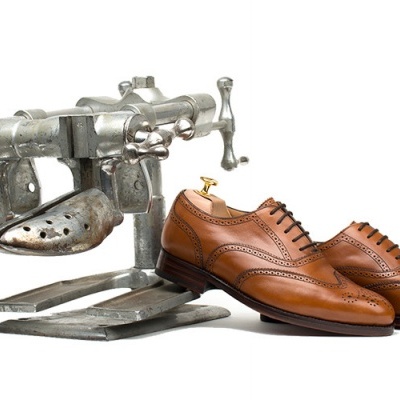 Sapatos de couro castanho claro com calçadorde metálico ao lado