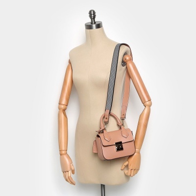 Mala de senhora pequena cor de rosa com alça às riscas num manequim bege com braços de madeira