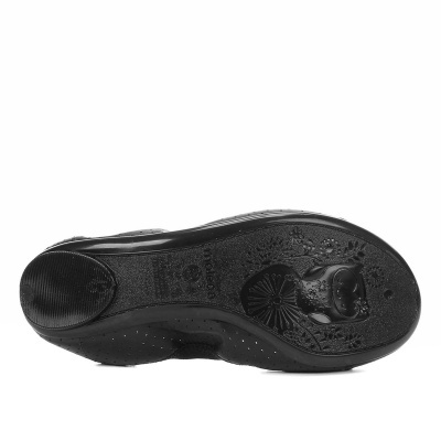 Sola preta de sapato com padrão floral e figura de gato em relevo