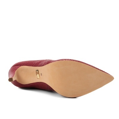 Salto alto bordô com textura de pele de cobra visto pela sola