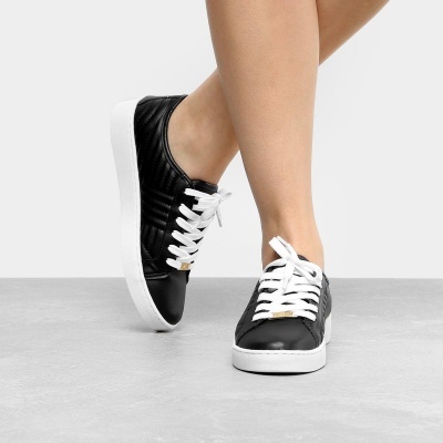 Tênis pretos com cadarços brancos e sola branca