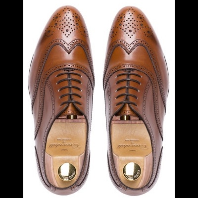 Sapatos castanhos de couro com padrão perfurado e cadarços pretos