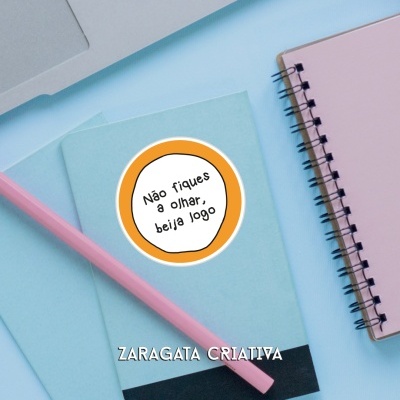 Cadernos azuis com autocolante e lápis rosa numa mesa azul