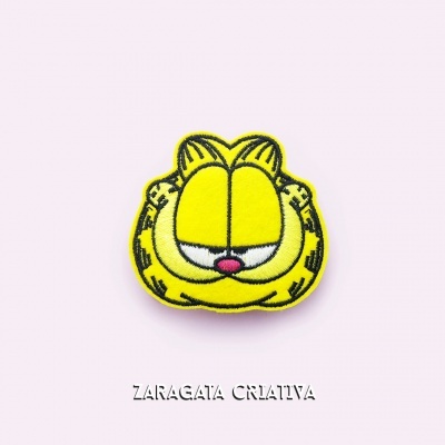Emblema bordado do rosto do gato Garfield com fundo rosa e texto ZARAGATA CRIATIVA