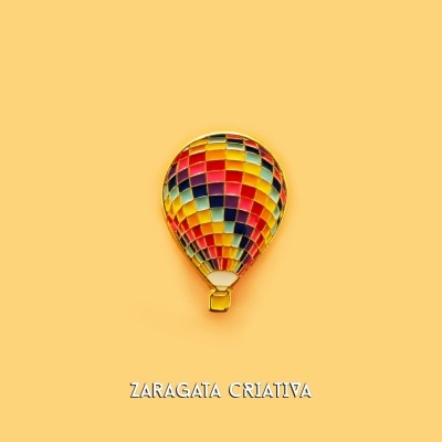 Balão de ar quente colorido com padrão quadriculado em fundo amarelo com texto 'ZARAGATA CRIATIVA'