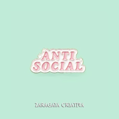 Pin metálico branco com letras cor-de-rosa 'ANTI SOCIAL' sobre fundo verde água