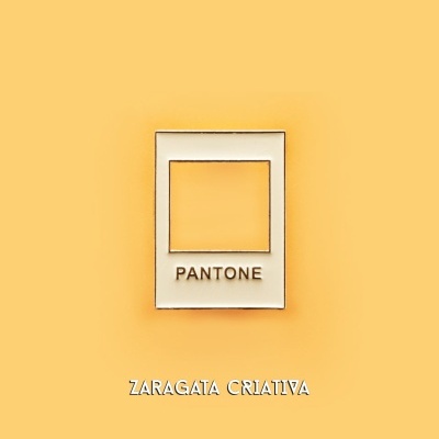 Pin metálico formato quadrado com a palavra PANTONE sobre fundo amarelo