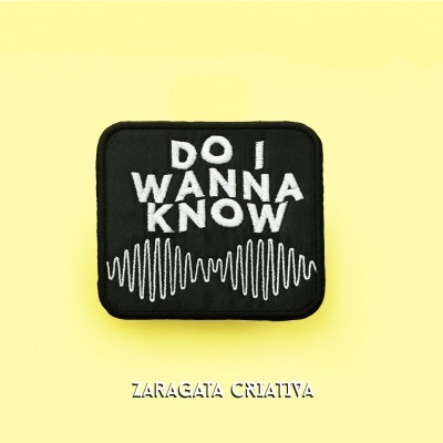 Patch preto com texto branco 'DO I WANNA KNOW' e padrão ondulado em fundo amarelo