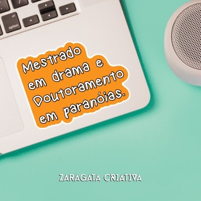 Computador portátil com autocolante com texto MESTRADO EM DRAMA E DOUTORAMENTO EM PARANÓIAS